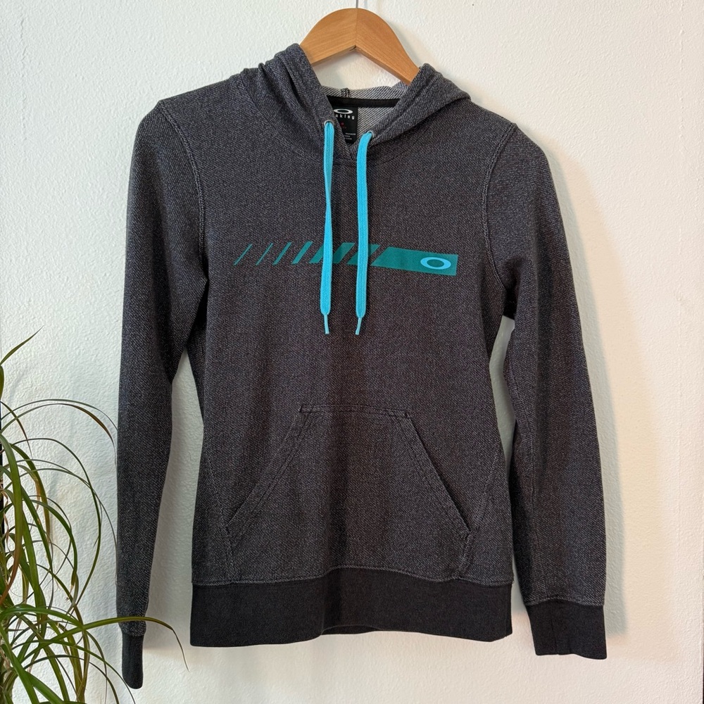 Oakley Charcoal Hoodie w/ a front pocket and Blue Drawstrings.